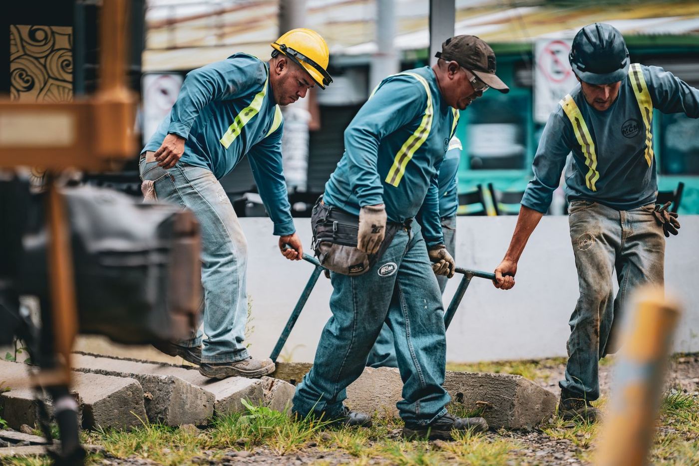 Trabalhadores com colete e capacete de segurança durante atividade prática de treinamento